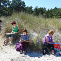 Kunst in den Dünen – Malerinnen sitzen in den Dünen und arbeiten an ihren Kunstwerken